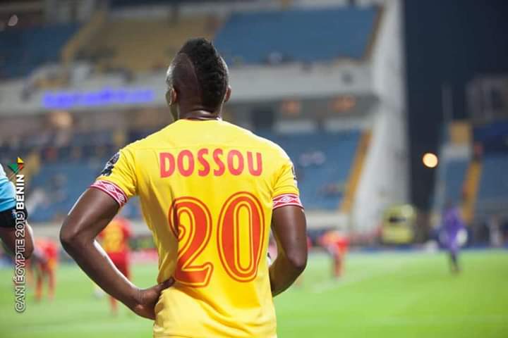 Joueur en maillot jaune numéro 20 vu de dos sur un terrain de football pendant un match