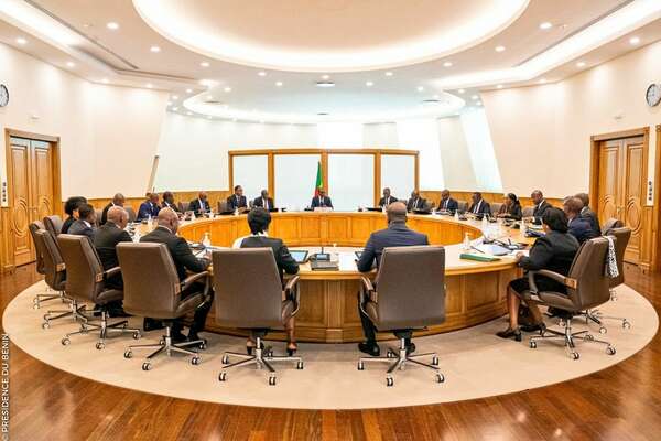 Des personnes assises autour d’une grande table ronde dans une salle de réunion lumineuse et formelle