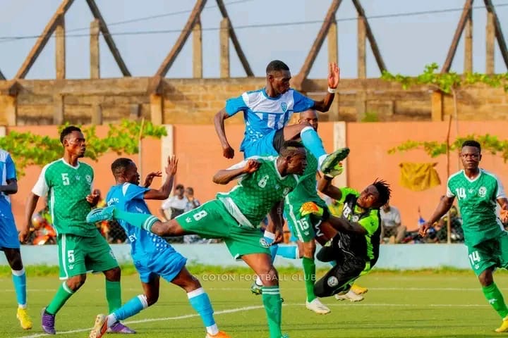 Joueurs en action lors d un match de football avec un joueur en bleu sautant par-dessus plusieurs adversaires en vert sur le terrain