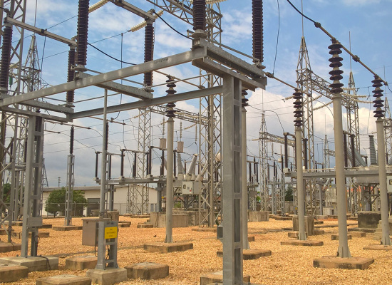Installation électrique composée de pylônes, câbles et équipements dans une station de distribution électrique en plein air