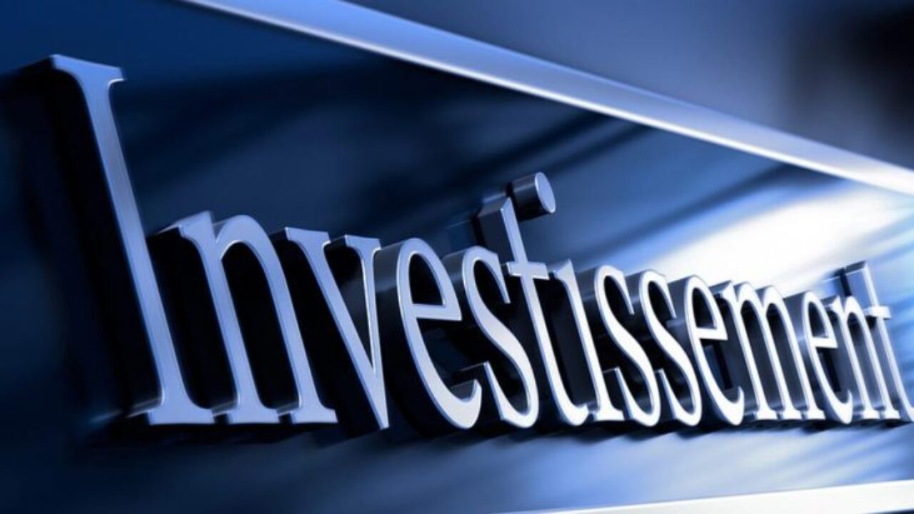 Le mot Investissement en gros plan sur un fond bleu avec un éclairage métallique réfléchissant