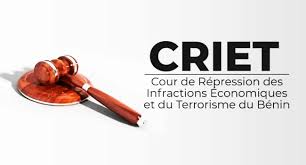 Un marteau de juge posé à côté du sigle CRIET sur fond blanc