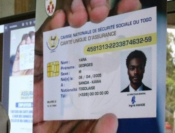 Main tenant une carte d'assurance sociale avec photo d'un homme et informations personnelles sur un fond flou