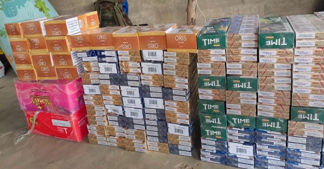 Paquets de cigarettes de différentes marques empilés en rangées au sol